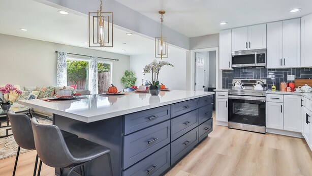 A modern kitchen with a large island, stainless steel appliances, and a dining area with a view. - The Escape Insurance approved Single story Pool (Los Angeles)