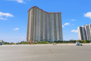 A high-rise hotel with multiple floors, a flat roof, and a beach in the foreground. - 9th-Floor Ocean View Condo, Pool & Hot Tub (Myrtle Beach)