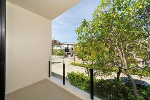 A balcony with a view of a tree and buildings. - Luxury 5 bed Laguna Park no pool (Tambon Choeng Thale)