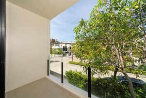 A balcony with a view of a tree and buildings.