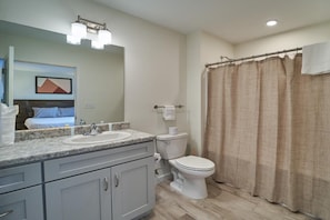 A bathroom with a sink, toilet, and shower curtain. - The Ruby 105 (Pigeon Forge)