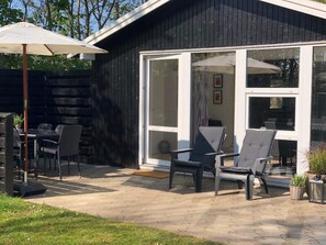 A modern building with large windows, outdoor seating, and a patio area. - 4 Star Holiday Home in Esbjerg V (Esbjerg)