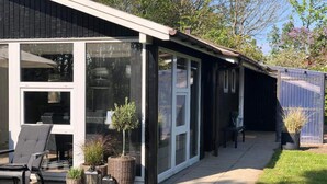 A modern building with large windows, outdoor seating, and potted plants. - 4 Star Holiday Home in Esbjerg V (Esbjerg)