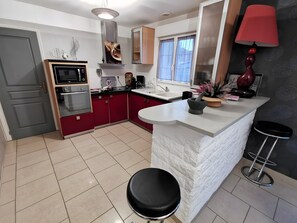 A modern kitchen with a built-in oven, microwave, and a large island with a sink. - Holiday Home 'Gîte À Proximité De Blois Chambord' with Private Terrace, Private Garden and Wi-Fi (Les Montils)