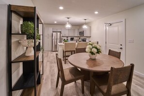 A modern kitchen with white cabinets, a central island, and pendant lighting. - The Ruby 201 (Pigeon Forge)