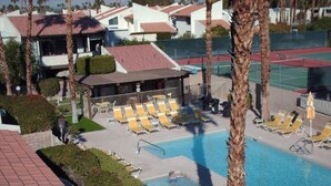A pool area with sun loungers, a small pool, and a covered seating area. - two bedrooms, two bathrooms, a full kitchen, living and dining areas. (Palm Springs)