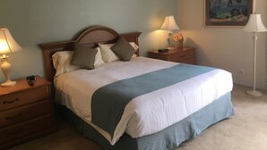A bedroom with a bed, nightstands, lamps, a painting, and a floor lamp. - two bedrooms, two bathrooms, a full kitchen, living and dining areas. (Palm Springs)