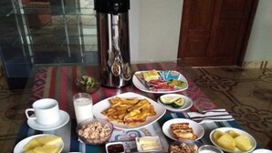 Een ontbijttafel met diverse producten, zoals pannenkoeken, eieren en avocado.