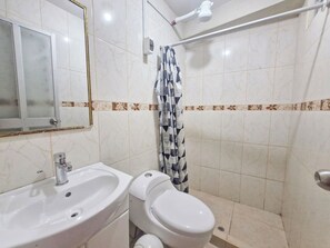 A bathroom with a white sink, toilet, and shower curtain. - Samaykuy (Urubamba)