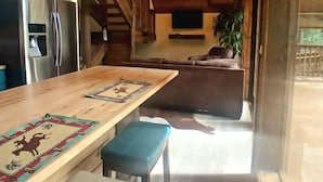 Un interior de madera con cocina, comedor y una escalera.