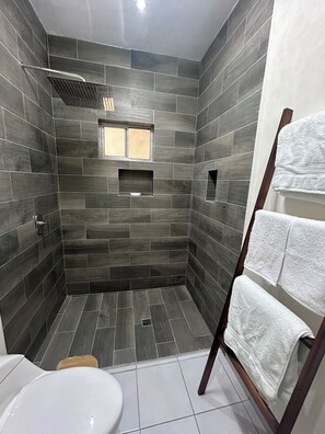 Een douche, handdoeken, zeep, toiletpapier