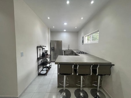 A kitchen with a central island, a refrigerator, and a window.
