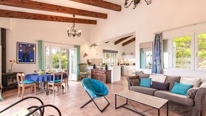 Amplia sala de estar con mesa de comedor, sofá y vista a la cocina.