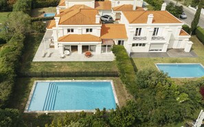 Una casa grande con piscina, patio y garaje.