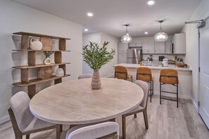 A modern kitchen with a round dining table, wooden shelves, and pendant lighting. - The Ruby 301 (Pigeon Forge)