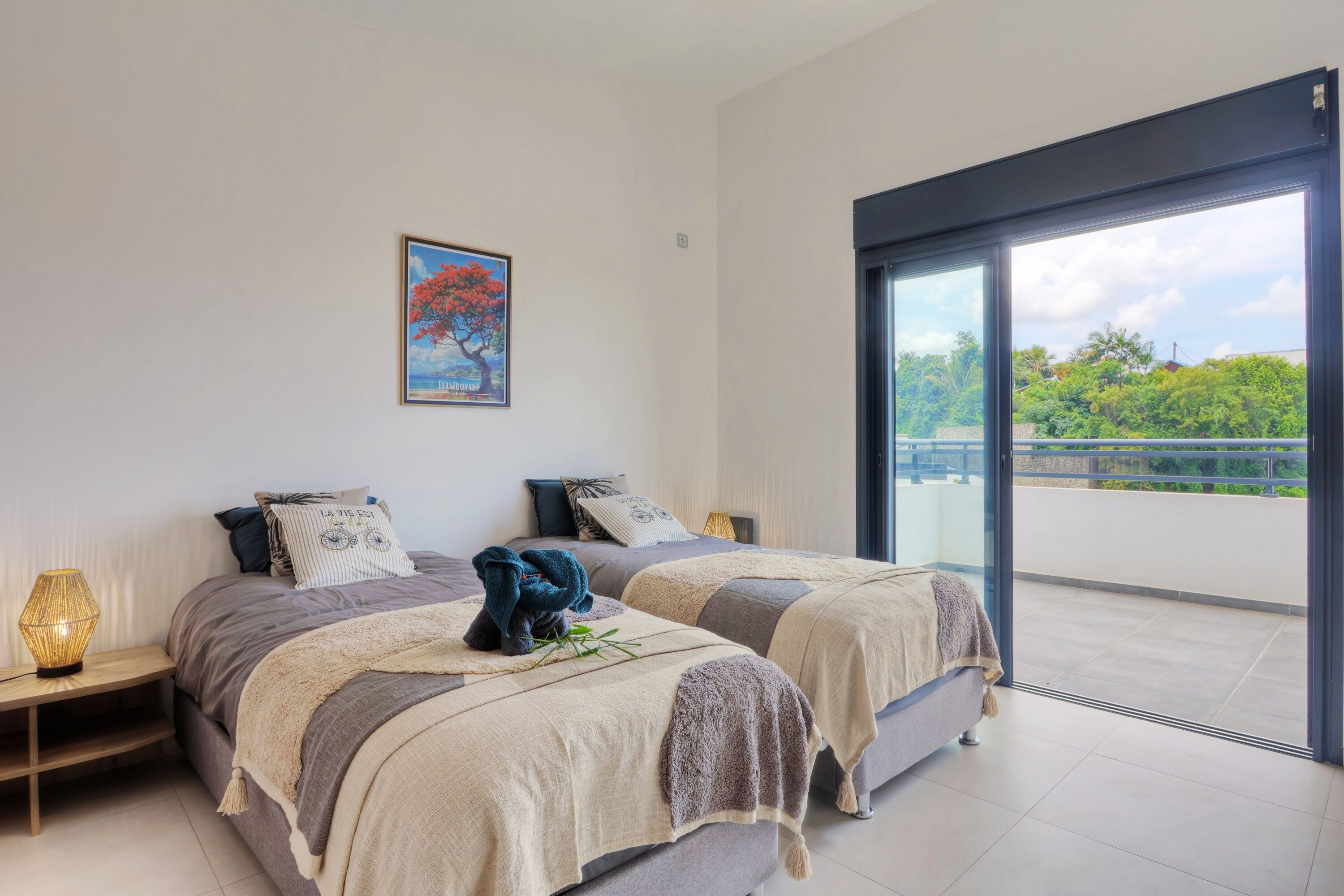 Una camera da letto con due letti, un'ampia finestra e un quadro appeso al muro.