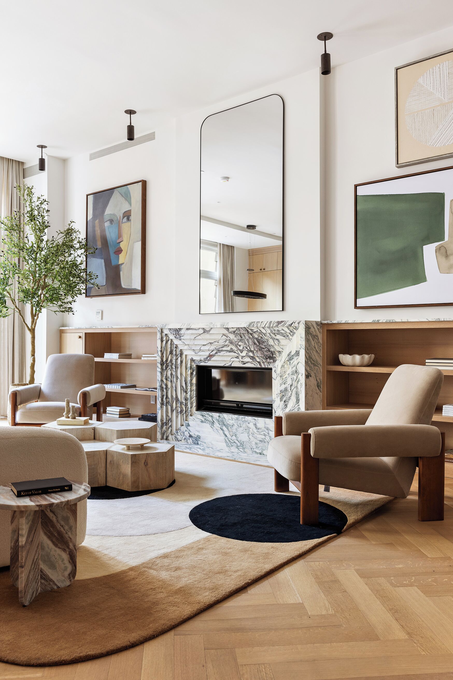 Un salon moderne avec une cheminée, des canapés, une table basse et un téléviseur.