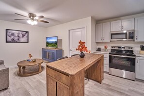 A modern kitchen with a wooden island, stainless steel appliances, and a ceiling fan. - The Ruby 308 (Pigeon Forge)