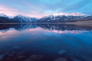 A tranquil mountain lake with snow-capped peaks and a clear reflection.
