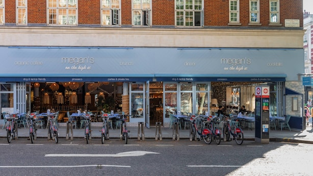 Un bâtiment doté d’une marquise bleue sur laquelle on peut lire l’inscription « Megan’s », proposant du café biologique, des repas de brunch, des dîners et des cocktails.