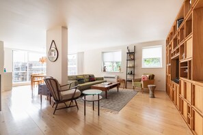 A spacious living room with a sofa, chairs, a coffee table, and a bookshelf. - Hardwick Street III - Two Bedroom Apartment, Sleeps 4 (London)