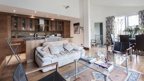 Un salon moderne avec un canapé, une table basse et un coin repas.