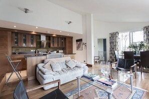Ein modernes Wohnzimmer mit Sofa, Couchtisch und Essbereich.