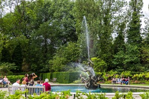 A fountain surrounded by lush greenery and people sitting on benches. - Regent's Park South - Two Bedroom Apartment, Sleeps 4 (London)