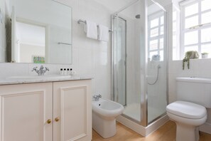 Une salle de bain moderne dotée d’une douche à parois de verre, d’un bidet et de toilettes.