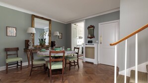 A dining area with a wooden table, chairs, and a mirror. - Courtfield Mews - Four Bedroom House, Sleeps 8 (London)