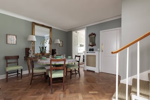 A dining area with a wooden table, chairs, and a mirror. - Courtfield Mews - Four Bedroom House, Sleeps 8 (London)
