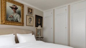 A bedroom with a large bed, a wardrobe, and framed portraits on the wall. - Courtfield Mews - Four Bedroom House, Sleeps 8 (London)