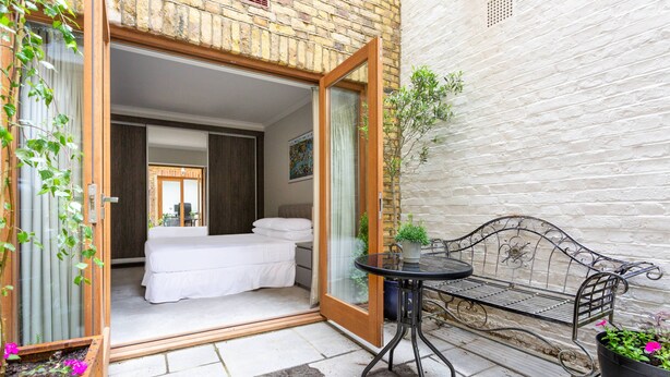 A room with a bed, a small table, and a bench. - Red Lion Square - Two Bedroom Apartment, Sleeps 4 (London)