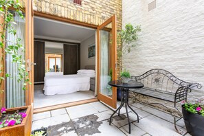 A room with a bed, a small table, and a bench. - Red Lion Square - Two Bedroom Apartment, Sleeps 4 (London)