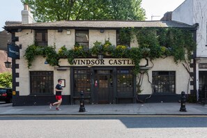 A building with a sign reading 'Windsor Castle' and a runner on the sidewalk. - Royal Crescent Mews - One Bedroom House, Sleeps 2 (London)