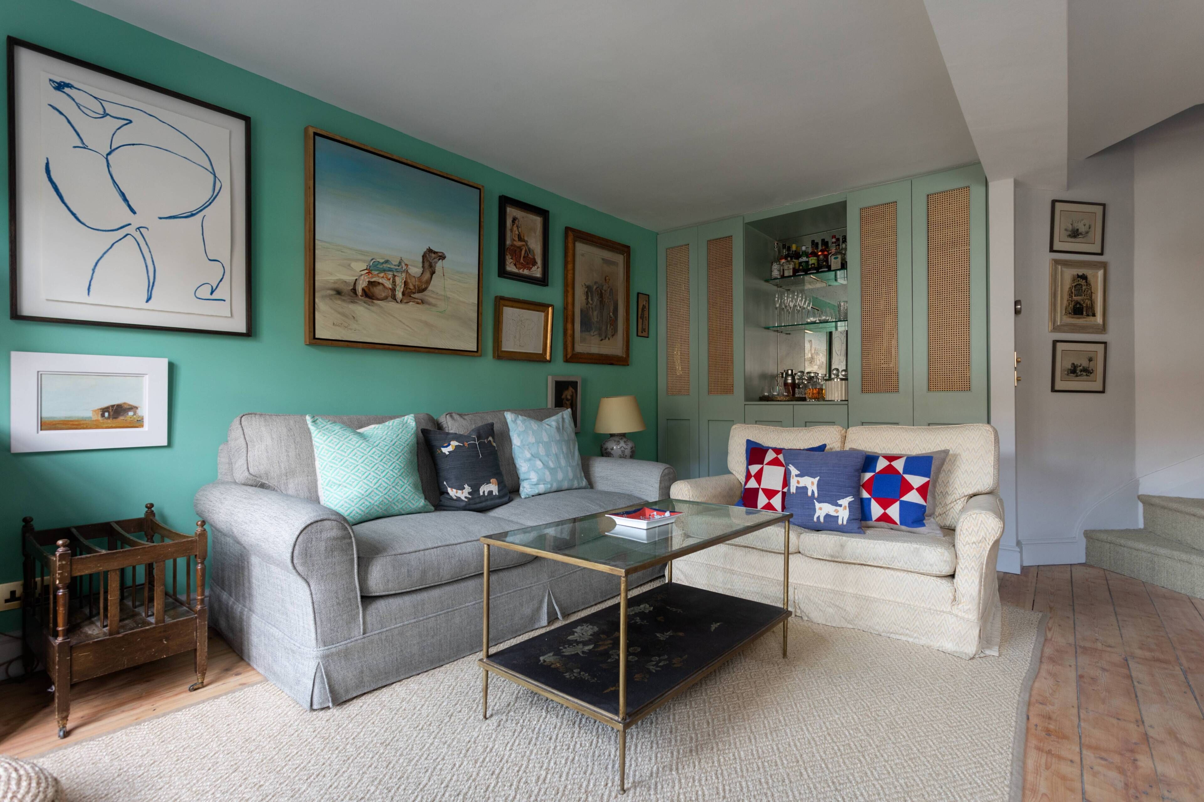 A living room with a sofa, a coffee table, and a crib.
