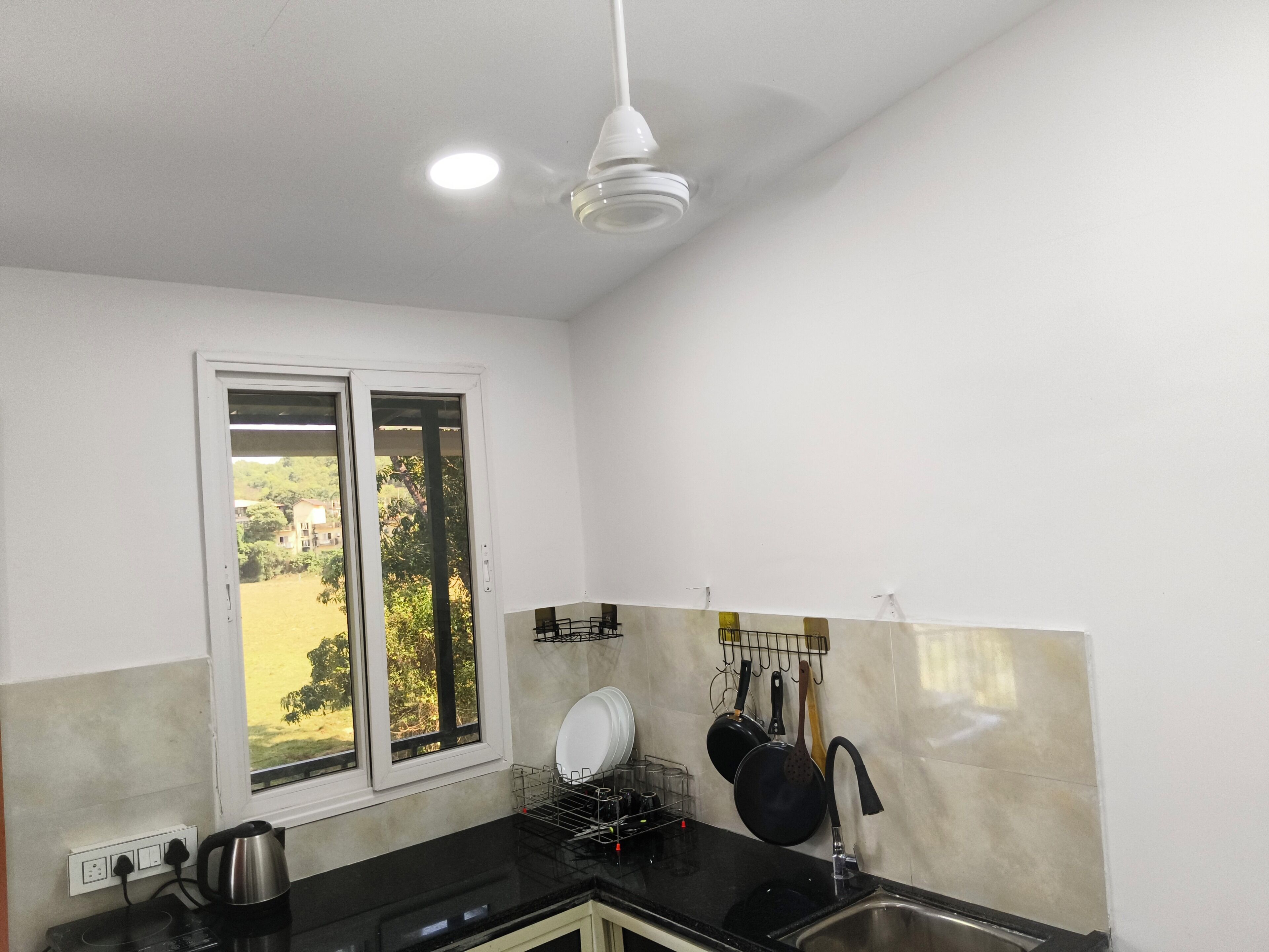 A kitchen with a window, a sink, and a dish rack.