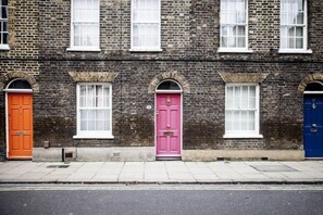 A row of three-story brick buildings with distinctively colored doors. - Theed Street - Two Bedroom Apartment, Sleeps 5 (London)