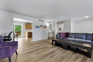 A modern living room with a sofa, a coffee table, and a purple chair. - The Rad Pad - Arcades, Seasonal Pool (Boise)