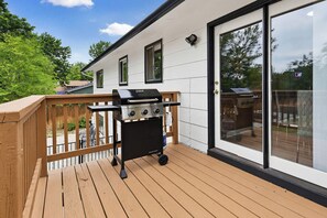 A deck with a grill, a sliding glass door, and a view of a backyard. - The Rad Pad - Arcades, Seasonal Pool (Boise)