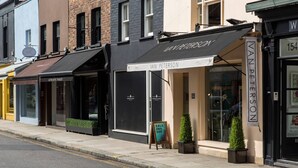 A row of storefronts with awnings, including one named 'VAN PETERSON.' - Gledhow Gardens - Two Bedroom Apartment, Sleeps 4 (London)