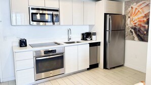 A modern kitchen with stainless steel appliances, a dishwasher, and a refrigerator. - Elegant 1BR, Marina View, Pool & Beach Shuttle (Hallandale Beach)