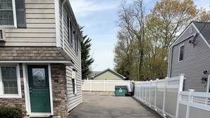 A residential street with houses, a driveway, and a white fence. - Brilliant, plush studio apartment in Brightwaters,NY .Bars and restaurants 3mins (Brightwaters)