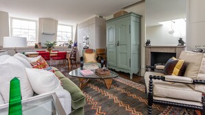 Ein Wohnzimmer mit Sofa, Sesseln, Couchtisch und Kamin.