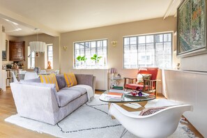 A living room with a sofa, armchair, coffee table, and a dining area with a table and chairs. - Wyndham Mews III - Three Bedroom House, Sleeps 6 (London)