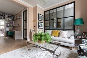 Ein Wohnzimmer mit einer Couch, einem Couchtisch und einem Bücherregal.