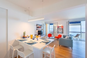 Un interno moderno con zona pranzo, illuminazione vivace e vista sul mare.