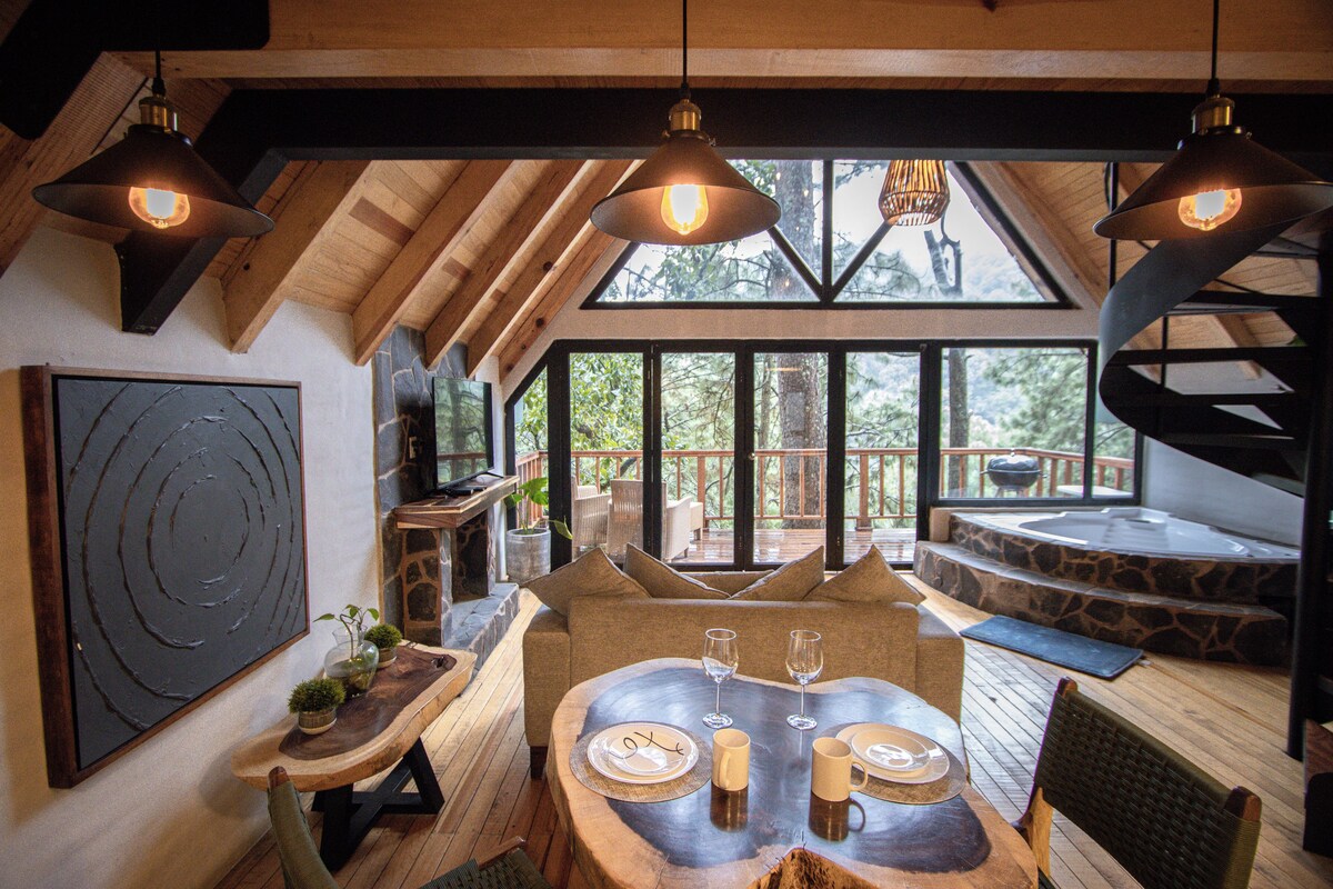 A dining area with a wooden table, chairs, and a large window offering a view of the outdoors.