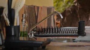 Una cocina con encimera negra, grifo y cafetera.