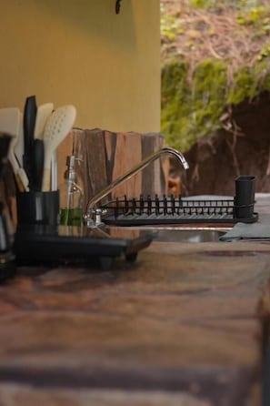 A kitchen with a black countertop, a faucet, and a coffee machine. - Cabañas VIP Mazamitla (Mazamitla)